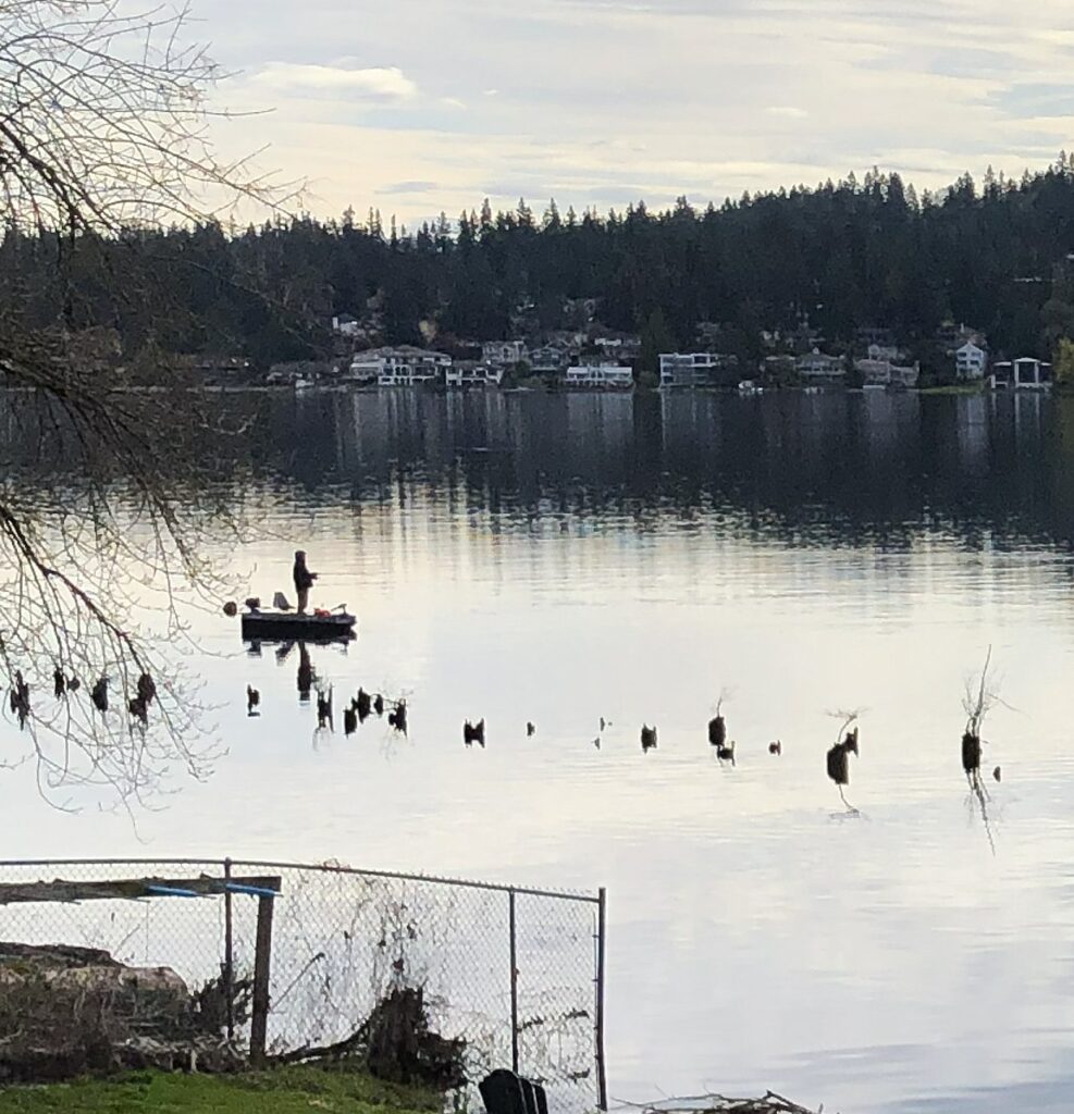 Reflections on rippled water img 8339 man on boat and trees